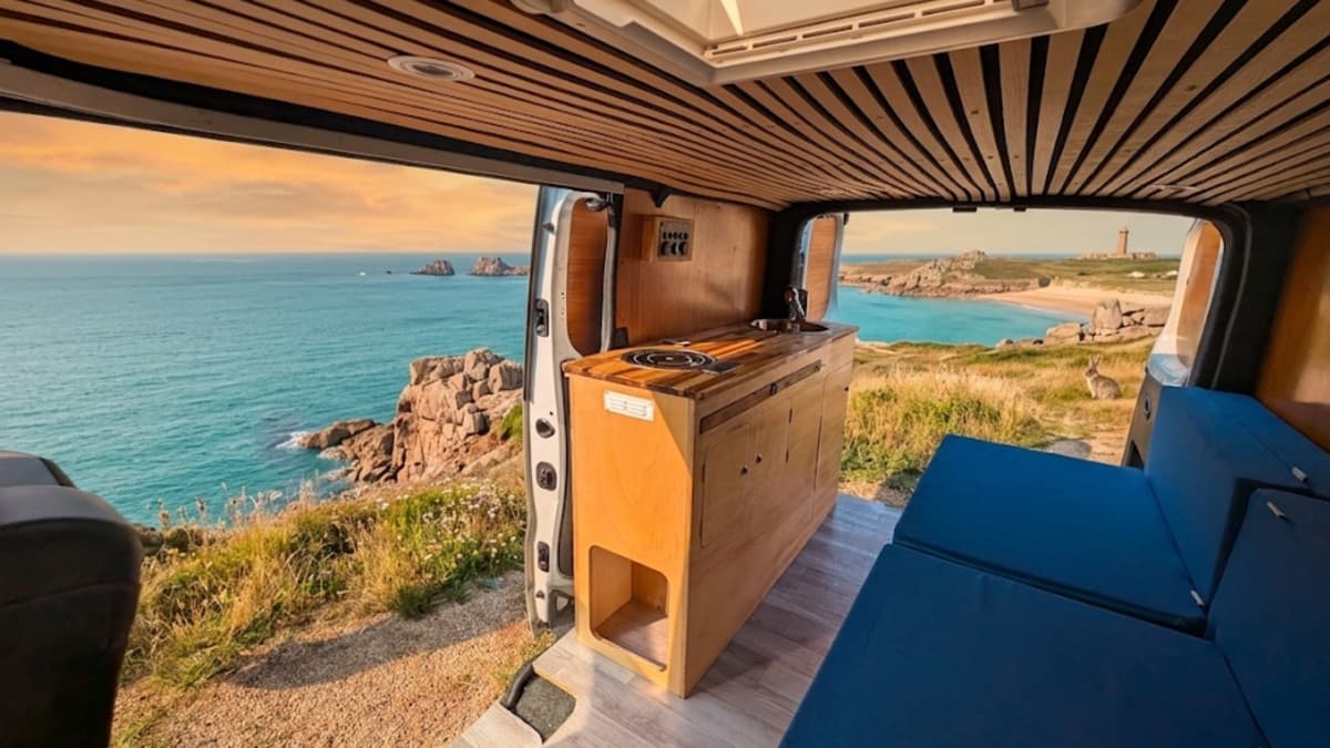 Intérieur d'un van aménagé Vanzon face à une plage du Pays Basque